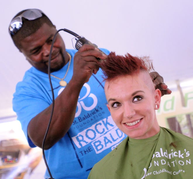 Alliance barber Herb Watson, left, shaves a head full of hair from Massillon's Hanna Hartman at the 2017 St. Baldrick's Alliance held at Buffalo Wild Wings. Hartman participated in support of family members who have had cancer.