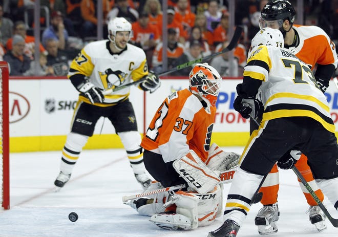 The puck bounces back out of the net behind Flyers goalie Brian Elliott after the Penguins' Justin Schultz, not pictured, scored on the power play in Game 3 Sunday at the Wells Fargo Center. [TOM MIHALEK / THE ASSOCIATED PRESS]