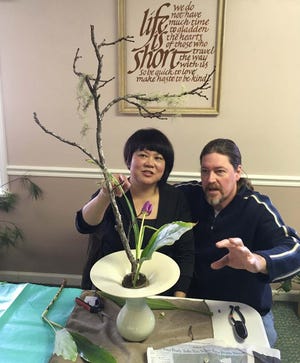 Ikebana instructor Emiko Suzuki critiques an arrangement by student John Lawson, who began receiving instruction in 2011 in the traditional Japanese art. [Photo by Beth de Bona/Special to the Times-News]