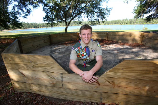 Joe Veale, a member of Boy Scout Troop 172, based at Blessed Trinity Catholic Church, poses for a photo with his Eagle Scout community service project, a gaga ball pit for use by youngsters involved with the Camp SoZo outreach in the Ocala National Forest. [Bruce Ackerman/Staff photographer]