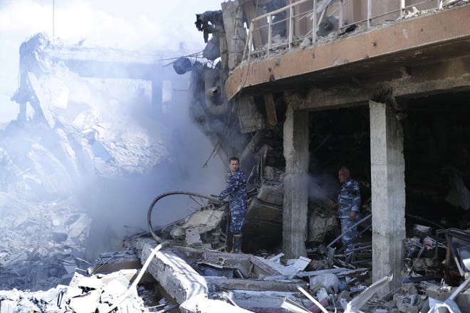 Firefighters extinguish smoke that rises from the damage of the Syrian Scientific Research Center which was attacked by U.S., British and French military strikes to punish President Bashar Assad for suspected chemical attack against civilians, in Barzeh, near Damascus, Syria, Saturday, April 14, 2018. The Pentagon says none of the missiles filed by the U.S. and its allies was deflected by Syrian air defenses, rebutting claims by the Russian and Syrian governments. Lt. Gen. Kenneth McKenzie, the director of the Joint Staff at the Pentagon, also says there also is no indication that Russian air defense systems were employed early Saturday in Syria. (AP Photo/Hassan Ammar)