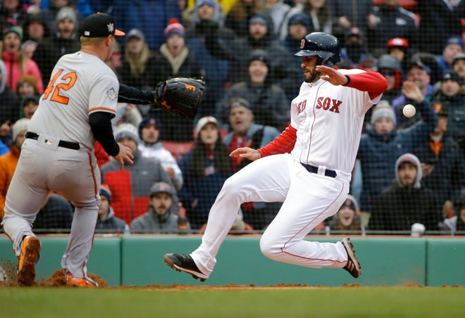 Boston Red Sox's J.D. Martinez, right, scores on a wild pitch by Baltimore Orioles' Dylan Bundy, left, in the sixth inning of a baseball game Sunday, April 15, 2018, in Boston. (AP Photo/Steven Senne)