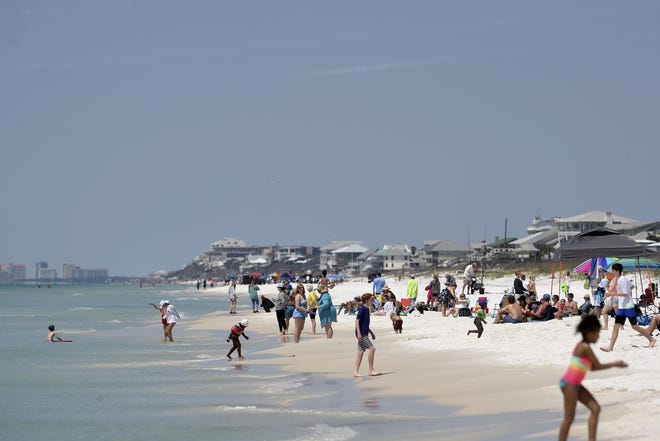 Beachgoers play on the sand and in the surf in Walton County. The county is one of those headlining the fight over public beach access in Florida. [DAILY NEWS PHOTO]