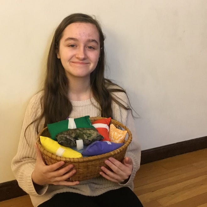 Carly O'Connell holds a basket of her homemade "port pillows" that she donated to Dana-Farber/Brigham and Women's Cancer Center at Milford Regional Medical Center.

[Contributed Photo]