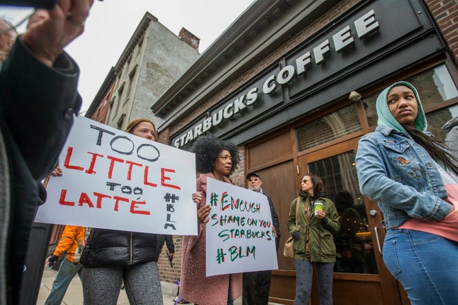 Protesters gather outside of a Starbucks in Philadelphia, Sunday, April 15, 2018, where two black men were arrested Thursday after employees called police to say the men were trespassing. The arrest prompted accusations of racism on social media. Starbucks CEO Kevin Johnson posted a lengthy statement Saturday night, calling the situation "disheartening" and that it led to a "reprehensible" outcome. (Michael Bryant/The Philadelphia Inquirer via AP)