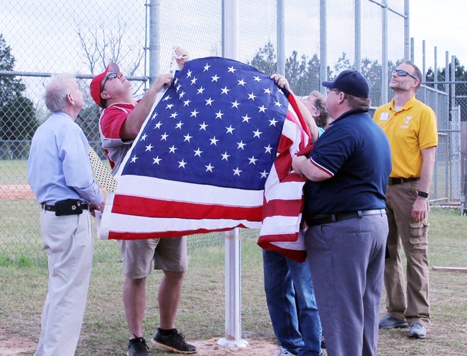 Charlie Prescott (at right), senior program director at the Family Y in Wrens, watches as an American flag is attached to the line that will allow the flag to be raised on the flag pole. WoodmenLife donated both the flag and the pole to the Y.

[Photos by Carol McLeod]