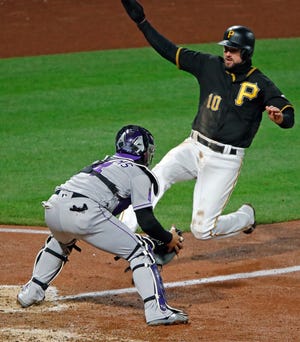 Colorado Rockies catcher Tony Wolters, left, takes the throw from third baseman Ryan McMahon and waits to tag out Pittsburgh Pirates' Jordy Mercer who was attempting to score from third on a fielder's choice by Pirates' Sean Rodriguez during the eighth inning of a baseball game in Pittsburgh, Tuesday, April 17, 2018. The Rockies won 2-0. (AP Photo/Gene J. Puskar)