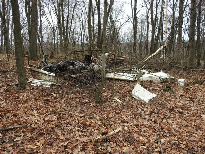 The wreckage of a small crash is strewn about in a wooded area near County Road 401 between Tiverton and Spring Mountain, Monday, April 16, 2018, near Coshocton, Ohio. Authorities say the single-engine plane was headed to Florida when it crashed in rural Ohio, killing two people on board. (Leonard L. Hayhurst/The Tribune via AP)