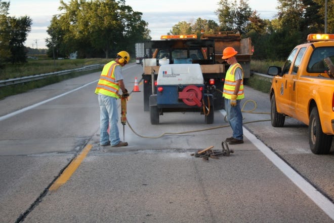 Ionia County Road Commission employees work to fix a pothole. [Contributed]