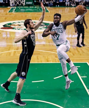 Celtics guard Jaylen Brown (7) drives to the basket against Bucks' center Tyler Zeller, left, during the first quarter of Tuesday's Game 2 in Boston. [Charles Krupa/AP]