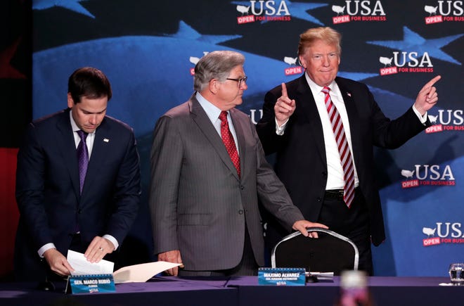 President Donald Trump, right, gestures as he arrives for a roundtable discussion on tax cuts in Hialeah with Sen. Marco Rubio, R-Fla., left, and center, and Sunshine Gasoline Distributors, Inc., president Maximo Alvarez. [AP Photo/Lynne Sladky]