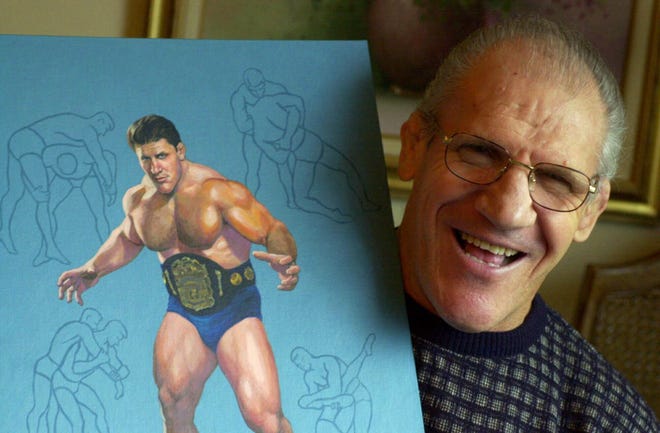 In this Nov. 30, 2000, file photo, former pro wrestler Bruno Sammartino, 65, poses with a painting of him in his pro wrestling prime weighing 275 pounds in 1965 at age 35, in his Pittsburgh home. Bruno Sammartino, professional wrestling's "Living Legend" and one of its longest-reigning champions, has died. Sammartino was 82. Family friend and former wrestling announcer Christoper Crusie saids Sammartino died Wednesday morning, April 18, 2018, and had been hospitalized for two months. (AP Photo/Gene J. Puskar, File)