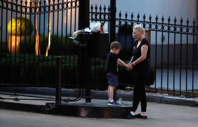 Amanda Gross holds the hands of her 6-year-old son, Patrick Henry, as they pray outside of the gated community where former first lady Barbara Bush died earlier in the day, Tuesday, April 17, 2018, in Houston. "Since he was in my womb, I have read him stories about more first ladies than presidents," Gross said. "Barbara Bush was the appropriate political figure. She will be missed," said Gross. (Karen Warren/Houston Chronicle via AP)