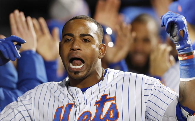 New York Mets' Yoenis Cespedes celebrates with teammates in the dugout after hitting a grand slam in the eighth inning against the Washington Nationals on Wednesday night in New York. [Kathy Willens/The Associated Press]