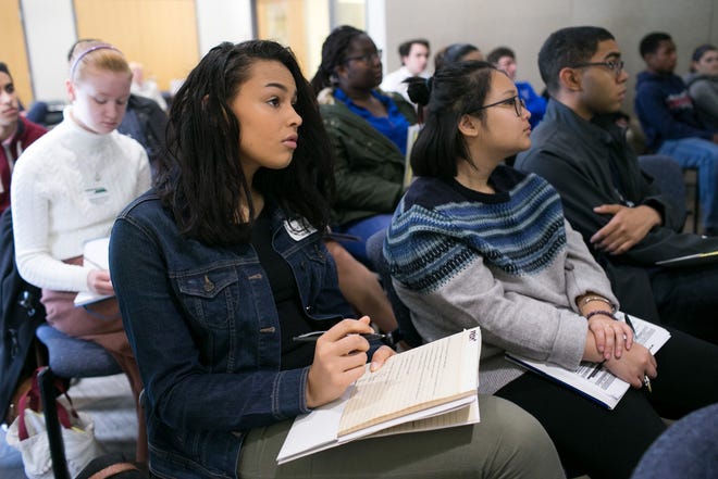 Alivia Thomas, 17, of Worcester takes notes during a talk by Nathan Angelo, assistant professor of political science at Worcester State University, on the two-party political system in the United States, Wednesday at Worcester State. [Photo/Matthew Healey]