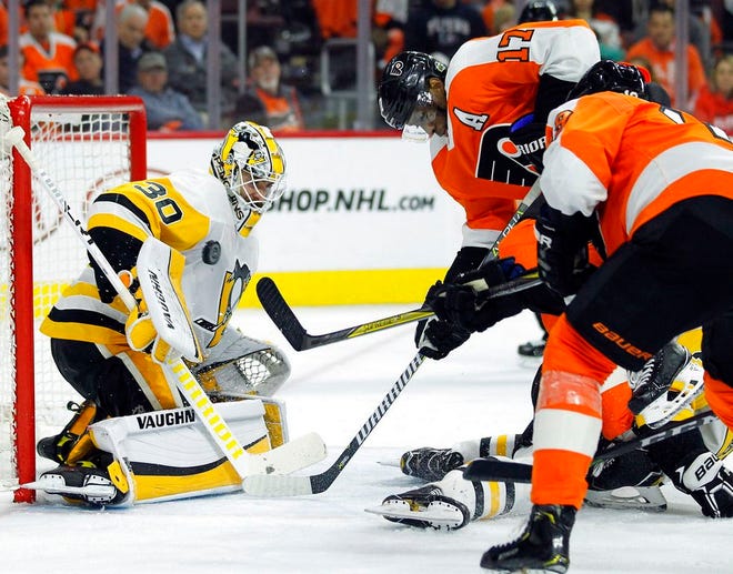 Pittsburgh Penguins goalie Matthew Murray, left, stops a shot as Philadelphia Flyers' Wayne Simmonds, center, and Nolan Patrick, look for a rebound during the second period in Game 4 of an NHL first-round hockey playoff series Wednesday, April 18, 2018, in Philadelphia. (AP Photo/Tom Mihalek)