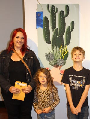 Artist Christence Taylor poses with her children, Leona and Fedor, and her work, 'Guarded Girl,' which won Best in Show at the 55th Bay Annual. [CONTRIBUTED PHOTOS]