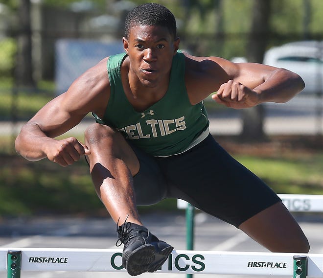 Jordan Lewis, a senior, clears a hurdle on the track at Trinity Catholic High School in Ocala, Fla. on Wednesday, April 18, 2018. Lewis, a standout on the Trinity Catholic track team, plans on attending Southern University in Baton Rouge, LA, next year on a football scholarship. He is a Star-Banner A to Z player. [Bruce Ackerman/Ocala Star-Banner] 2018.