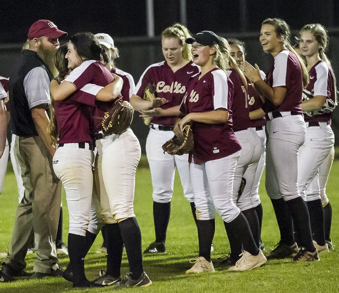 North Marion's Joscelynne McQuaig, second from left, hugs pitcher Amy Kennedy after North Marion defeated West Port 4-1 in extra innings after scoring three runs in the 10th inning Thursday night. Mcquaig hit a triple in the 10th inning to drive in two runs to help with the win. [Doug Engle/Staff photographer]