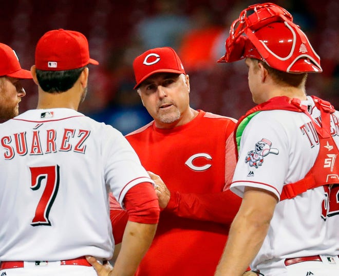 FILE - In this Aug. 23, 2017, file photo, Cincinnati Reds manager Bryan Price, center, waits on the mound after removing starting pitcher Asher Wojciechowski during the fourth inning of a baseball game against the Chicago Cubs, in Cincinnati. The Reds have fired Bryan Price after a 3-15 start, the first managerial change in the major leagues this season. Price was in his fifth season leading the rebuilding team. The Reds have lost at least 94 games in each of the last three seasons while finishing last in the NL Central. Bench coach Jim Riggleman will manage the team on an interim basis.(AP Photo/John Minchillo, File)