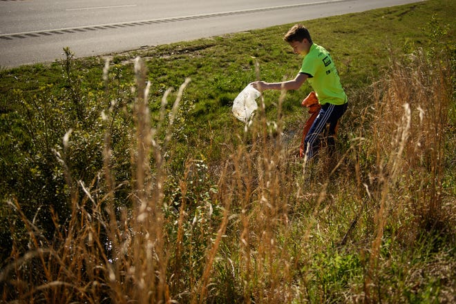 Sean Ross, 14, picks up trash along the Martin Luther King Jr. Freeway during the 2017 Fayetteville Beautiful cleanup. This year's event is Saturday. [Andrew Craft/The Fayetteville Observer]