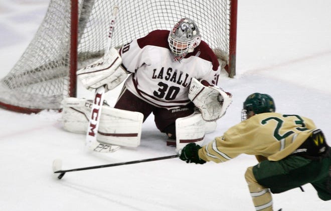 All-State goalie Justin Spencer of La Salle makes a save on Hendricken's Matt Dumond during the third game of the state championship series.