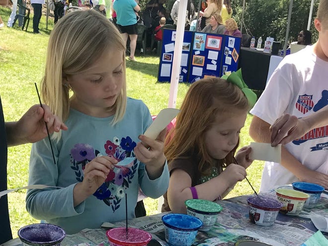 Aly Shelton and Emmalyn Johnson work on bookmarks to take home from the Kings Mountain Earth Day celebration. [Joyce Orlando/The Star]