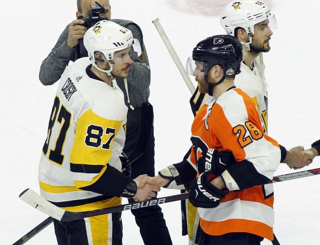 Penguins captain Sidney Crosby, and Philadelphia Flyers captain Claude Giroux shake hands at the end of Game 6 on Sunday in Philadelphia. [Tom Mihalek/The Associated Press]