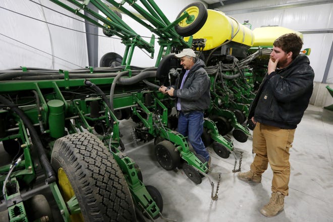 Farmers Bill Schrock and his son, Nate, ready a 24-row planting Wednesdayon the family farm in Oakville. The two hope to be out in the field planting corn sometime next week. [John Lovretta/thehawkeye.com]