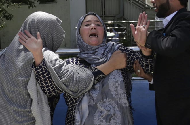A woman cries at a hospital after she lost her son in a suicide attack on a voter registration center in Kabul, Afghanistan, Sunday, April 22, 2018. Gen. Daud Amin, the Kabul police chief, said the suicide bomber targeted civilians who had gathered to receive national identification cards. (AP Photo/Massoud Hossaini)