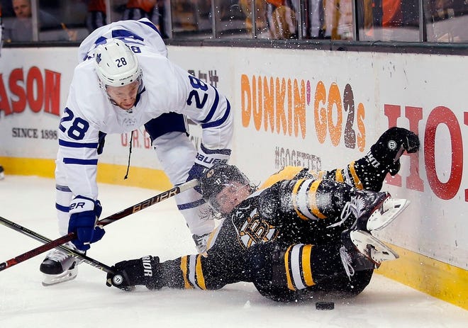 The Bruins' Torey Krug falls down while trying to corral a loose puck as the Maple Leafs' Connor Brown moves in during the third period of Game 5 on Saturday. The Maple Leafs won, 4-3, and trail the series, 3-2.