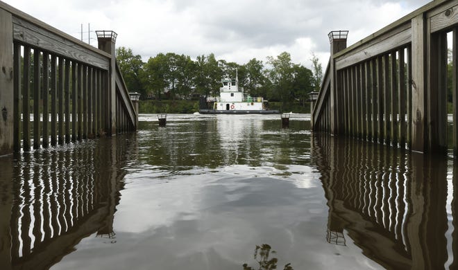 The Black Warrior River, shown here Monday as a tugboat pushes down the river past a flooded pier on the Tuscaloosa Riverwalk, reached 134 feet in Tuscaloosa after Sunday's rain. Flood stage on the river is 140 feet. [Gary Cosby Jr./Staff Photo]
