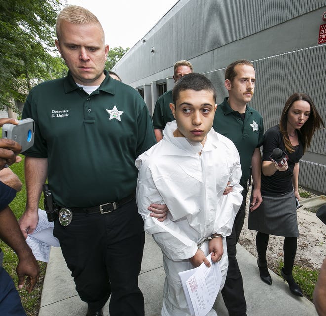 Marion County Sheriff's Detectives John Lightle, left and Dan Pinder, right, escort Forest High shooting suspect Sky Bouche, 19, center, to a waiting patrol car Friday. [Doug Engle/Staff photographer]