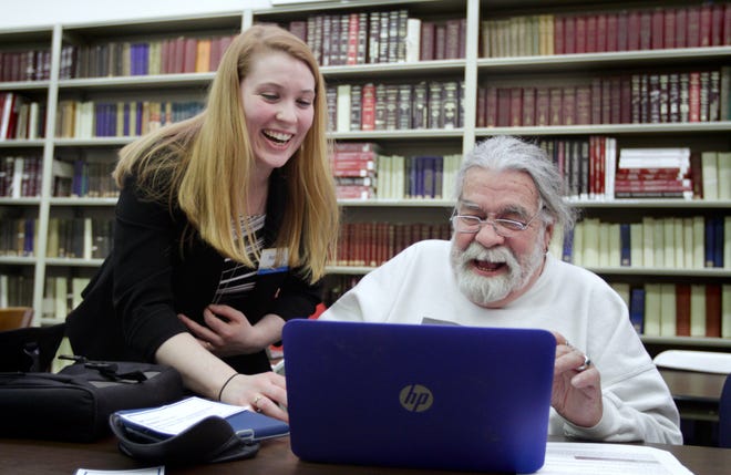 Rhode Island State Archivist Ashley Selima works with volunteer Joe Quigley of New Bedford in February as he helps transcribe some of the millions of documents in the Rhode Island State Archives. [The Providence Journal, file / Kris Craig]