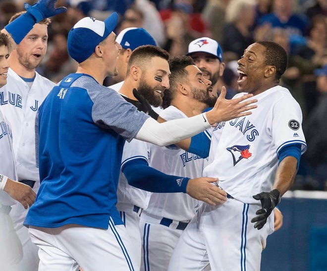 Toronto's Curtis Granderson is greeted by teammates after his walk-off homer.