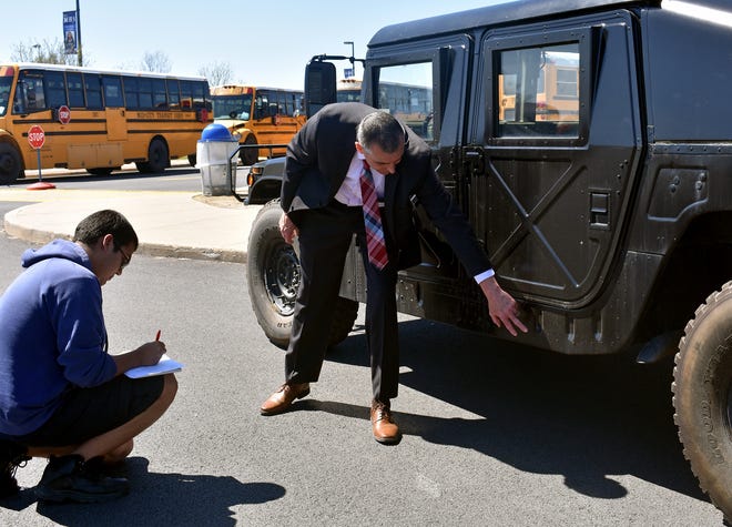 Middletown Police Chief John Ewanciw, right, makes a suggestion for designing the side of the military-style police vehicle to Middletown senior Luis Escobar. Escobar is trying to soften the look of the Humvee for the department so it can be used at community events. [LANA BELLAMY/TIMES HERALD-RECORD]