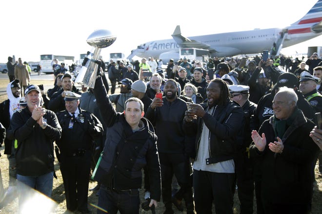 (File) Eagles general manager Howie Roseman shows the Vince Lombardi Trophy to fans after returning to Philadelphia following the team's Super Bowl LII win. [Julio Cortez/Associated Press]