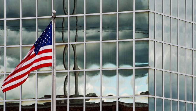 After several consecutive days of rain and clouds in the area, a small patch of blue sky peeps through a small break in the cloud cover, as reflected in the glass surface of First National Bank on Wednesday afternoon. [Donnie Roberts/The Dispatch]