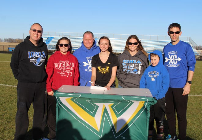 Chloe Wandell (center) is surrounded by coaches and family as she signs her Institutional Letter of Intent with Wayne State University. [Jeannie Gregory/Ionia Sentinel-Standard]