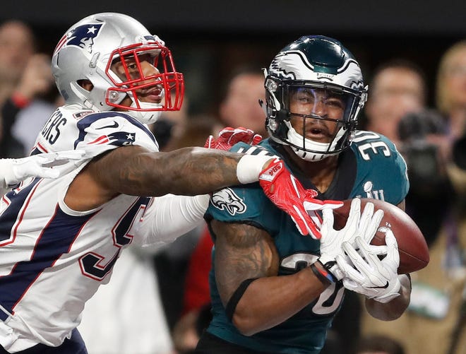 Philadelphia Eagles' Corey Clement, right, catches a touchdown pass in front of New England Patriots' Marquis Flowers during the second half of the Super Bowl in Minneapolis. [AP PHOTO/JEFF ROBERSON]