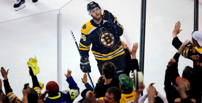 The Bruins' David Pastrnak celebrates with fans after scoring his second goal of the game in the third period.