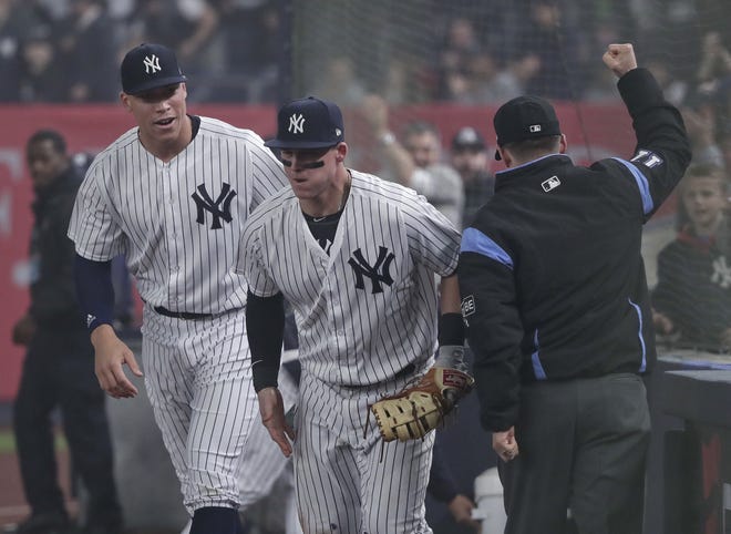 First-base umpire D.J. Reyburn signals an out after Yankees first baseman Tyler Austin, center, caught a pop-up in foul territory with the bases loaded to end the top of the seventh inning. [THE ASSOCIATED PRESS]