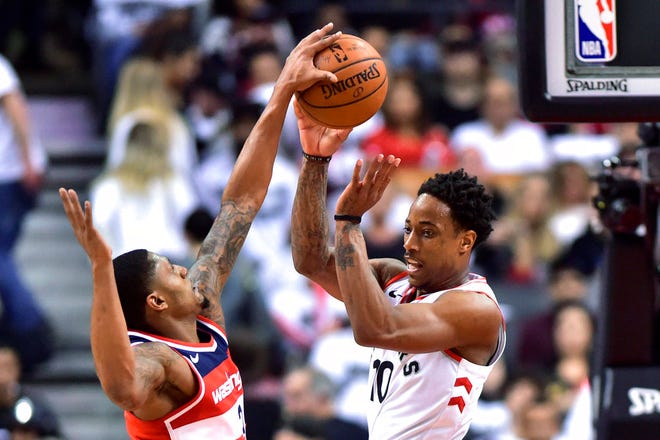 Washington Wizards' Bradley Beal gets a hand on the ball as Toronto Raptors' DeMar DeRozan defends during the second half of Game 5 of an NBA basketball first-round playoff series Wednesday, April 25, 2018, in Toronto. (Frank Gunn/The Canadian Press via AP)
