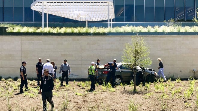 Police and EMS officials work at the scene where a woman drove her vehicle into a wall at Oracle’s Southeast Austin campus on Thursday. NICK WAGNER / AMERICAN-STATESMAN