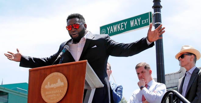FILE - In this June 22, 2017, file photo, retired Boston Red Sox designated hitter David Ortiz is honored with the renaming of a portion of Yawkey Way to David Ortiz Drive outside Fenway Park in Boston. The City of Boston approved a plan Thursday, April 26, 2018, to change the name of Yawkey Way to Jersey Street, it's original name. The street had been named in honor of former Red Sox owner Tom Yawkey, who some have said was racist. At center rear is Boston Mayor Marty Walsh, and at right is Red Sox principal owner John Henry. (AP Photo/Charles Krupa, File)