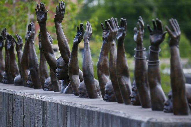 This photo shows a bronze statue called "Raise Up", part of the display at the National Memorial for Peace and Justice, a new memorial to honor thousands of people killed in lynchings, Monday, April 23, 2018, in Montgomery, Ala. The memorial and an accompanying museum that open this week in Montgomery are a project of the nonprofit Equal Justice Initiative, a legal advocacy group in Montgomery. (AP Photo/Brynn Anderson)