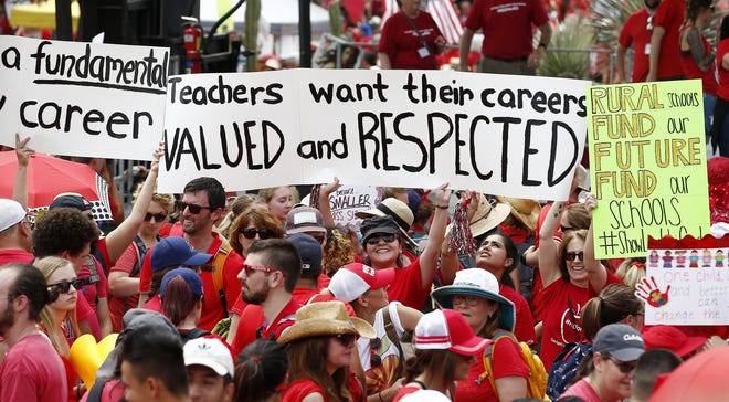 Thousands participate in a protest at the Arizona Capitol for higher teacher pay and school funding on the first day of a state-wide teachers strike Thursday, April 26, 2018, in Phoenix. A sea of teachers clad in red shirts and holding "Money for Schools" signs reached the Arizona Capitol to press lawmakers for action Thursday, a key event in an unprecedented walkout that closed most of the state's public schools and built on an educator uprising that bubbled up in other parts of the U.S. (AP Photo/Ross D. Franklin)