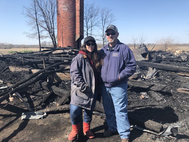 Lorelei Titus-Hooper and Brad Hooper stand Friday amid the ruble of what historically was known as the Houston Octagon Barn on their farm at 1561 320th Ave. east of Denmark, Iowa. The barn was destroyed by a fire Thursday after catching fire. The cause of the fire is not considered suspisious, but it remains under investigation. [Andy Hoffman/thehawkeye.com]