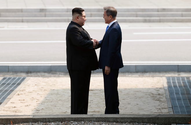 North Korean leader Kim Jong Un, left, shakes hands with South Korean President Moon Jae-in at the border village of Panmunjom in Demilitarized Zone Friday, April 27, 2018. North Korean leader Kim made history by crossing over the world's most heavily armed border to greet South Korean President Moon for talks on North Korea's nuclear weapons.(Korea Summit Press Pool via AP)