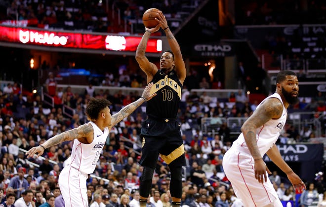 Toronto Raptors guard DeMar DeRozan (10) shoots over Washington Wizards forward Kelly Oubre Jr. (12) with Wizards forward Markieff Morris at right during the first half of Game 6 of an NBA basketball first-round playoff series, Friday, April 27, 2018, in Washington. (AP Photo/Alex Brandon)